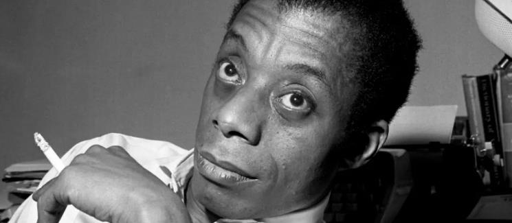 James Baldwin holding a cigarette between his fingers