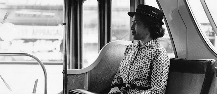 Rosa Parks on a bus looking out a window