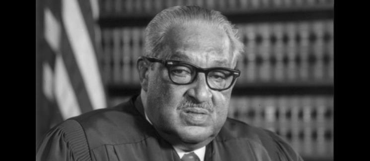 Thurgood Marshall in front of a bookcase