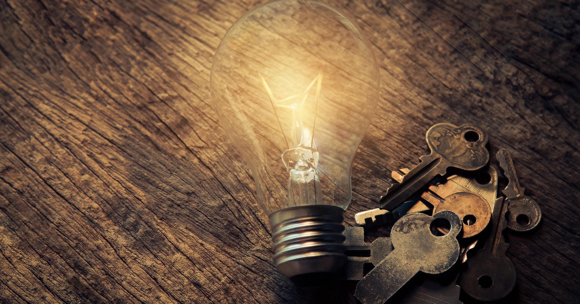 photo of an illunimated light bulb and keys