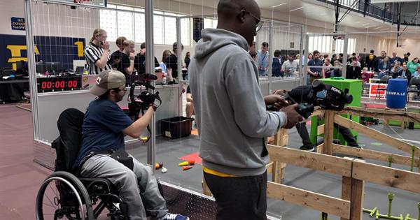 Students filming a robotics competition