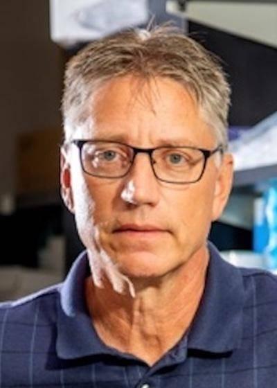 Dr. Douglas Thewke, Professor of the Department of Medical Education pictured wearing a blue shirt. of Douglas Thewke