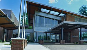 A front enterance picture of Franklin Woods Community Hospital. The building is mostly brick with tall, glass windows.